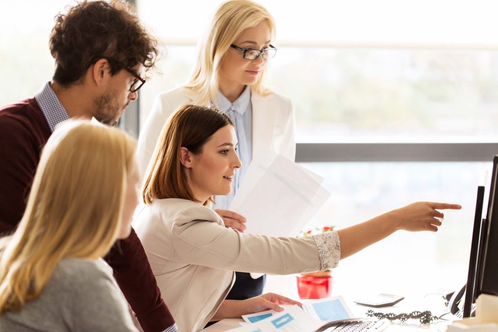 happy creative team with computer in office