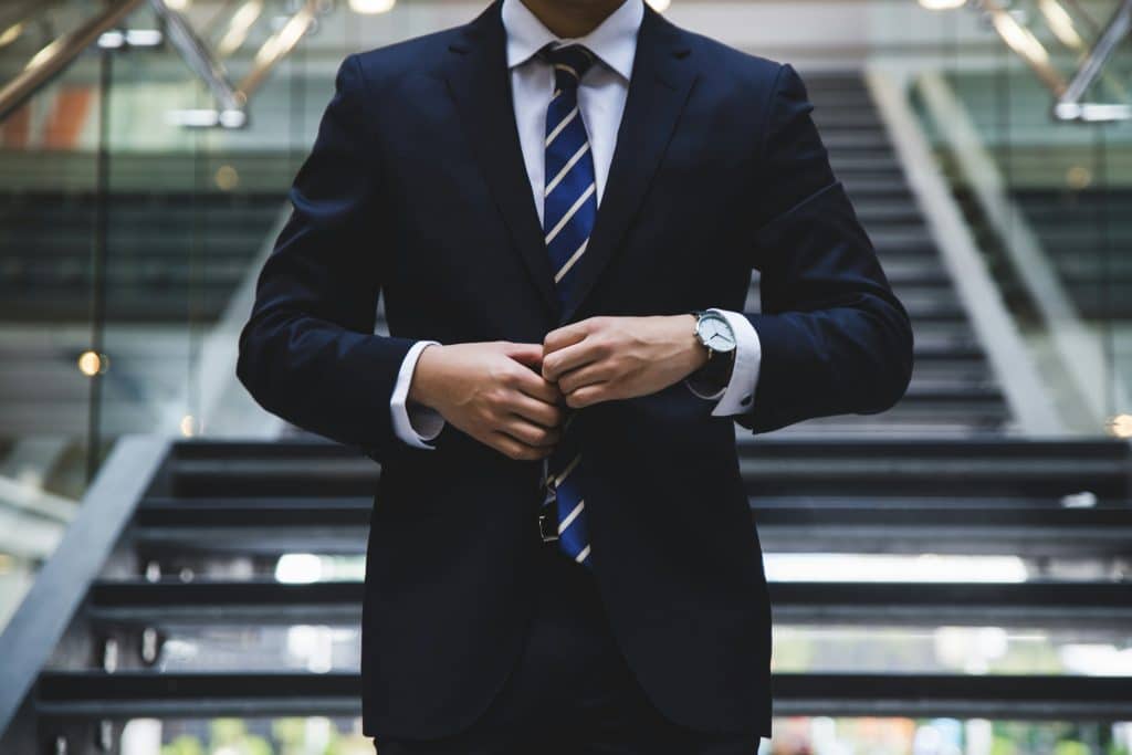 man in a business suit buttoning his jacket