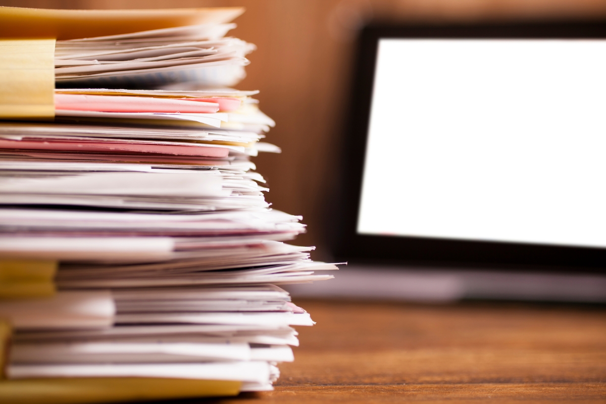 Stacks of resumes at a desk, surrounded by stacks of applications