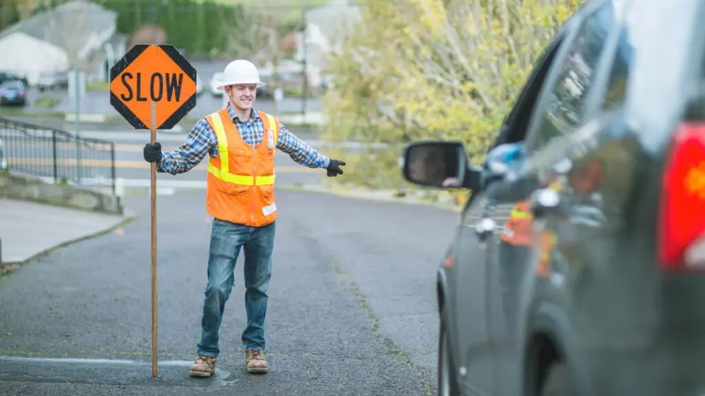 Highway flagger holding a sign saying slow
